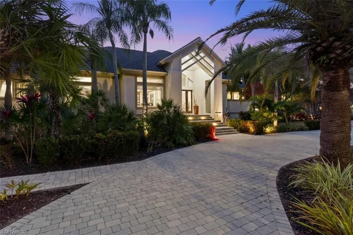 View of front of home with stucco siding and decorative driveway