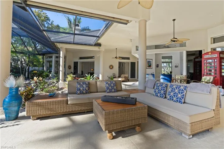 View of patio / terrace featuring a ceiling fan, a sunroom, glass enclosure, and an outdoor living space