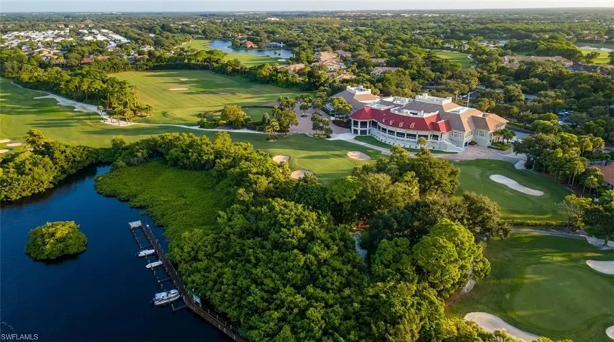 Aerial view of property's location with a golf club and a large body of water
