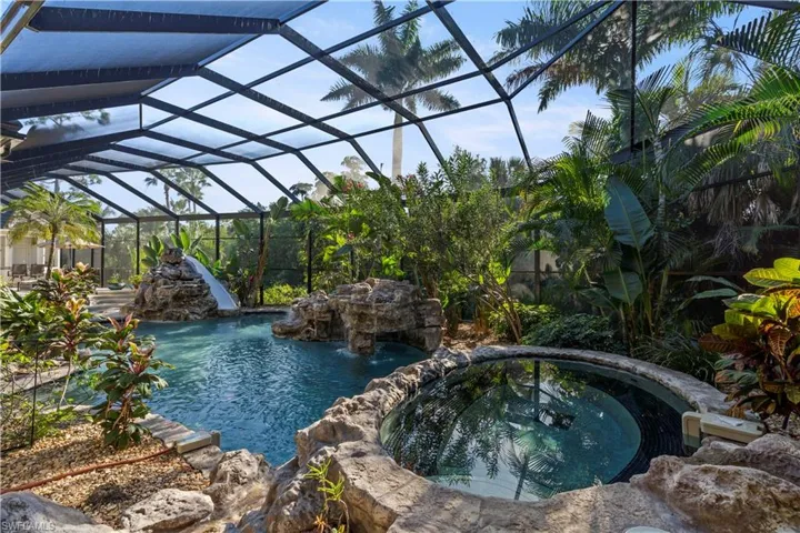 View of pool with a lanai, a sunroom, and a pool with connected hot tub