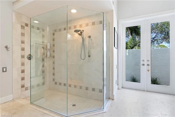 Bathroom featuring french doors, a stall shower, and recessed lighting