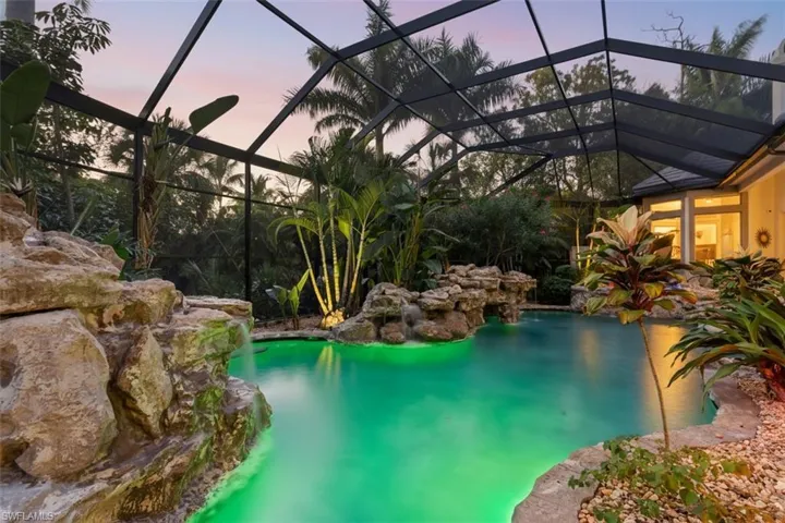Pool at dusk featuring a lanai, a sunroom, and an outdoor pool