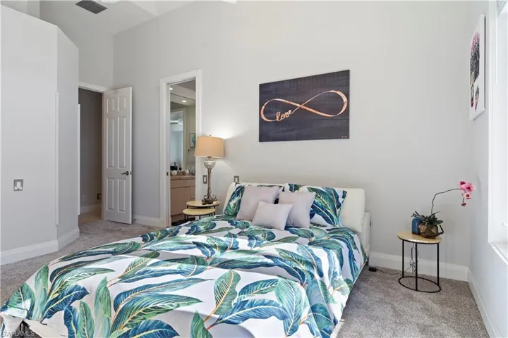 Bedroom with light colored carpet and ensuite bathroom