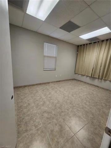 Spare room with tile flooring and a drop ceiling