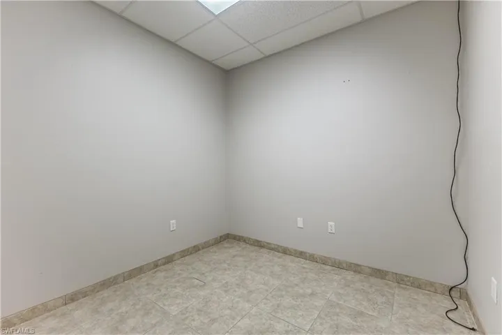 Spare room featuring a drop ceiling and baseboards
