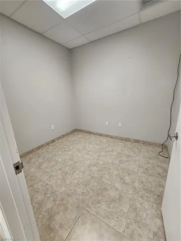 Tiled empty room with a drop ceiling