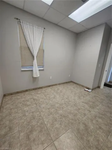 Spare room with tile flooring and a paneled ceiling