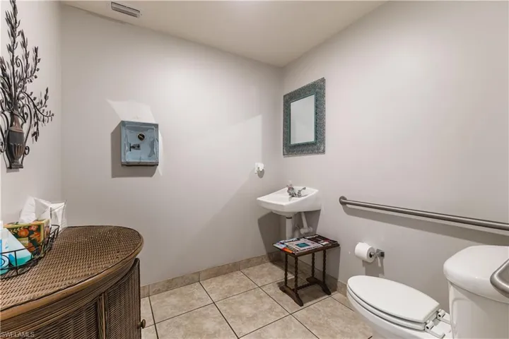Half bath with toilet and light tile patterned flooring