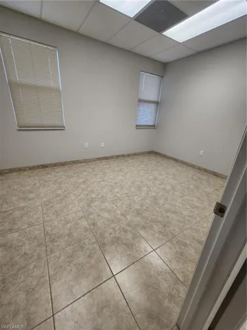 Unfurnished room with tile floors and a drop ceiling