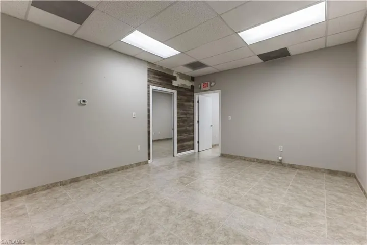 Unfurnished room featuring a paneled ceiling and baseboards