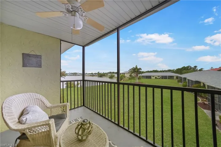 Sunroom with a ceiling fan, a water view, and a balcony