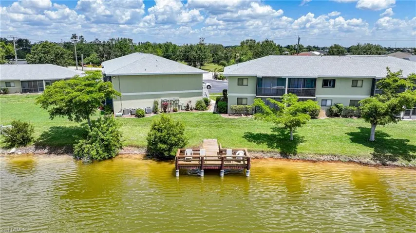 Dock area featuring a water view, a yard, and view of wooded area