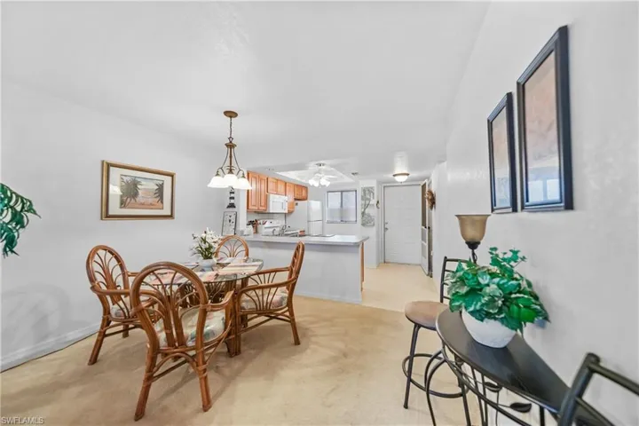 Dining area featuring light colored carpet and ceiling fan