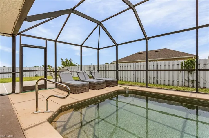 View of pool with a patio and glass enclosure