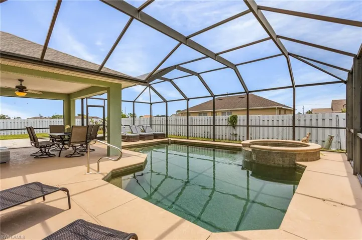 View of pool featuring ceiling fan, a patio area, a lanai, and an in ground hot tub