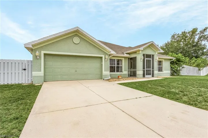 Ranch-style home with a garage and a front lawn