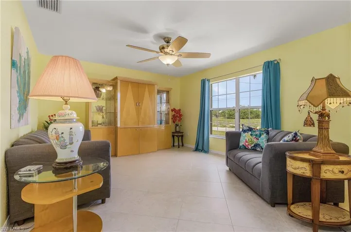 Tiled living room featuring ceiling fan