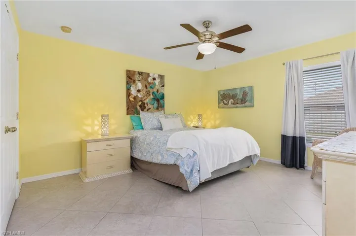 Bedroom featuring ceiling fan and light tile floors
