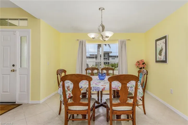 Tiled dining space featuring a notable chandelier