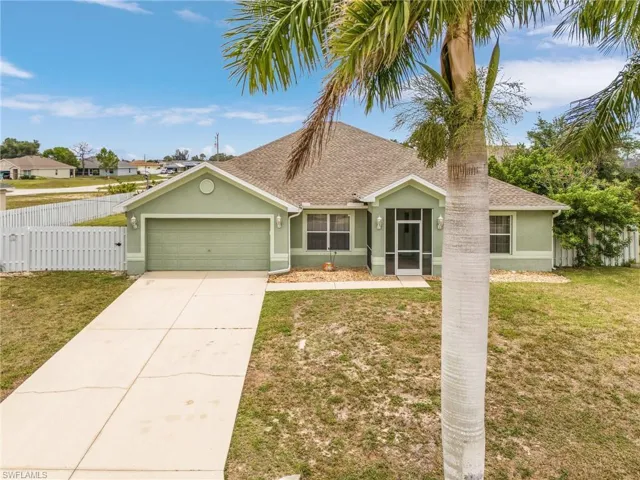 Ranch-style home featuring a front lawn and a garage