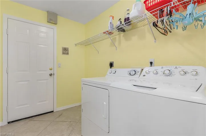 Laundry room featuring independent washer and dryer, hookup for an electric dryer, and light tile flooring