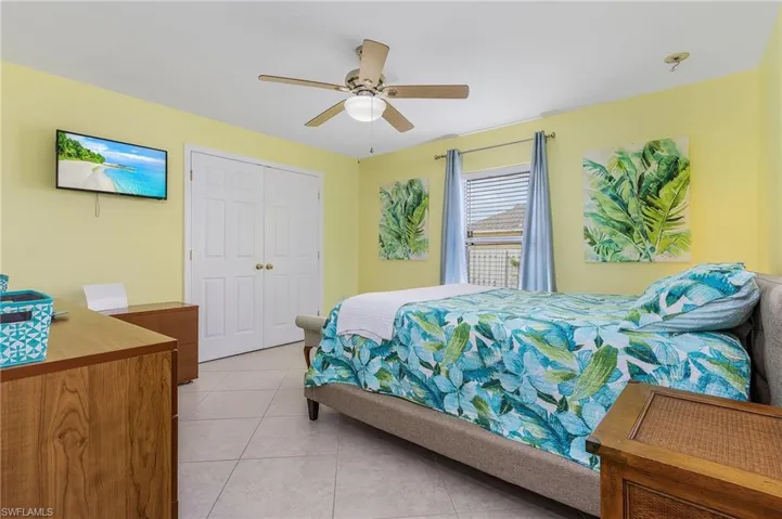 Bedroom with tile flooring, a closet, and ceiling fan