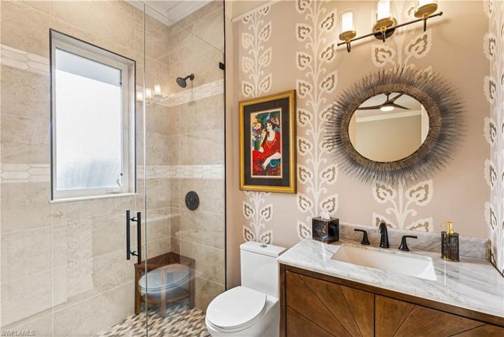 2nd ensuite bathroom. Custom wallpaper, floor to ceiling tile in walk in shower with seamless glass shower enclosure and double listello. Marble contertop vanity.