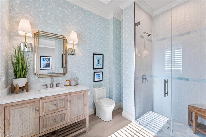 3rd bathroom has, marble countertop vanity, custom wallpaper, floor to ceiling tile in shower with double listello and seamless glass shower enclosure.