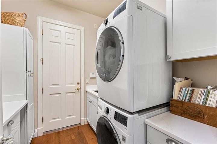 Laundry room features De Chateau wood flooring, Quartz countertops w/cabinetry, single vanity sink & LG stackable Washer and Dryer.