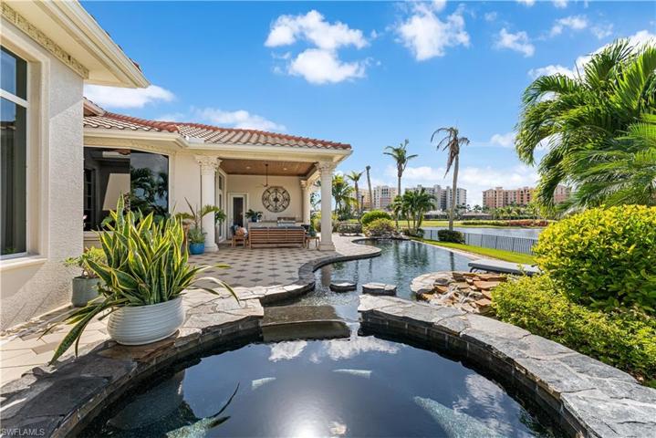 Infinity pool and spa w/2 rock waterfall features. Pecky Cypress wood ceiling on your lanai with a outdoor kitchen with AOG (American outdoor grill), sink. Pavered pattern deck w/Lounge and separate sitting areas