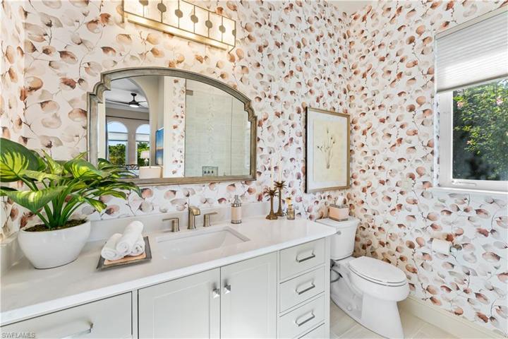 4th ensuite bathroom offers custom wallpaper, quartz countertop vanity, walk in shower with floor to ceiling tile and listello, seamless glass shower enclosure.