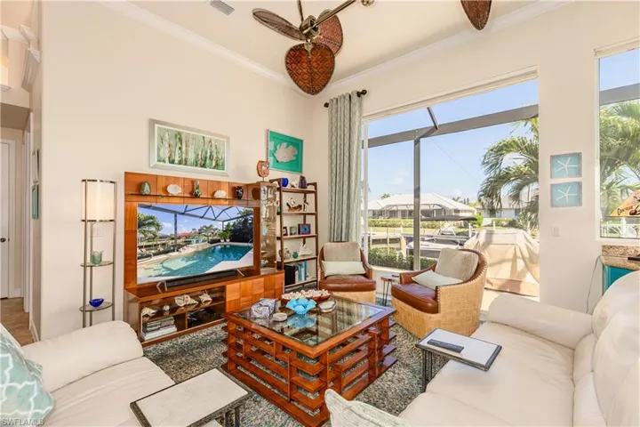 Living area featuring ceiling fan and crown molding