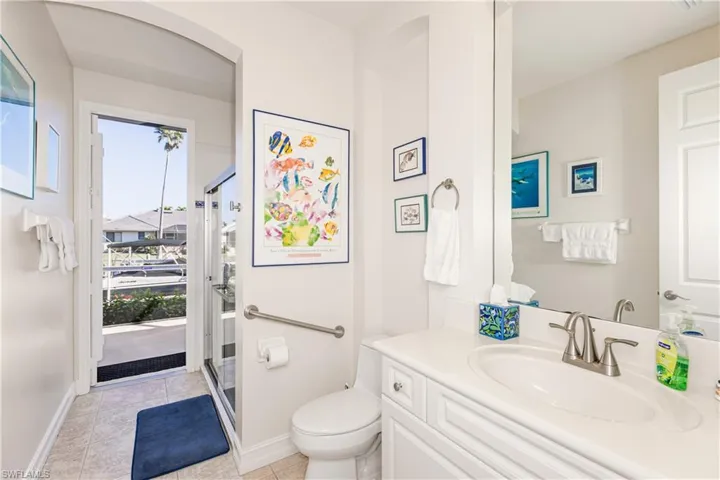 Bathroom featuring tile patterned flooring, baseboards, vanity, and toilet