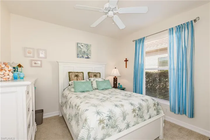 Bedroom with baseboards, a ceiling fan, and light colored carpet