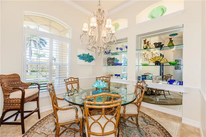 Dining area featuring tile patterned flooring, ornamental molding, a chandelier, and baseboards