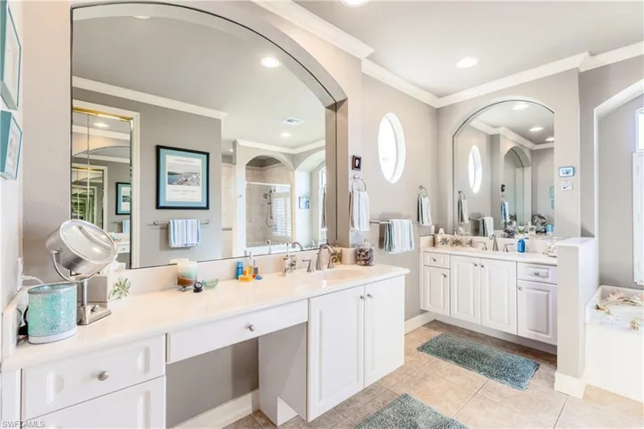 Full bathroom with ornamental molding, a stall shower, tile patterned flooring, and a sink