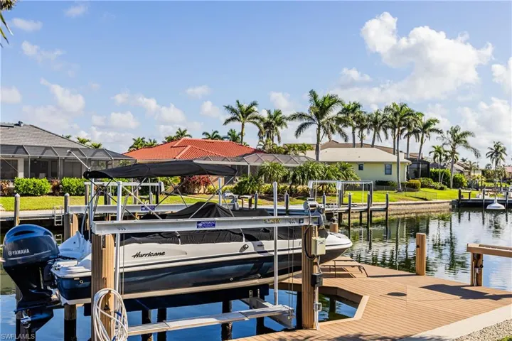 View of dock with a water view, boat lift, and a residential view