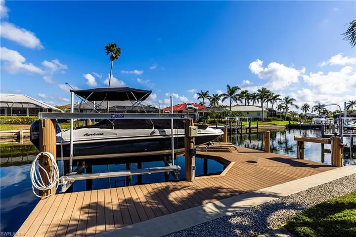 View of dock featuring a water view, boat lift, and a residential view