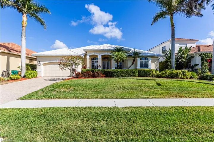Mediterranean / spanish house featuring an attached garage, decorative driveway, a front yard, and a tile roof