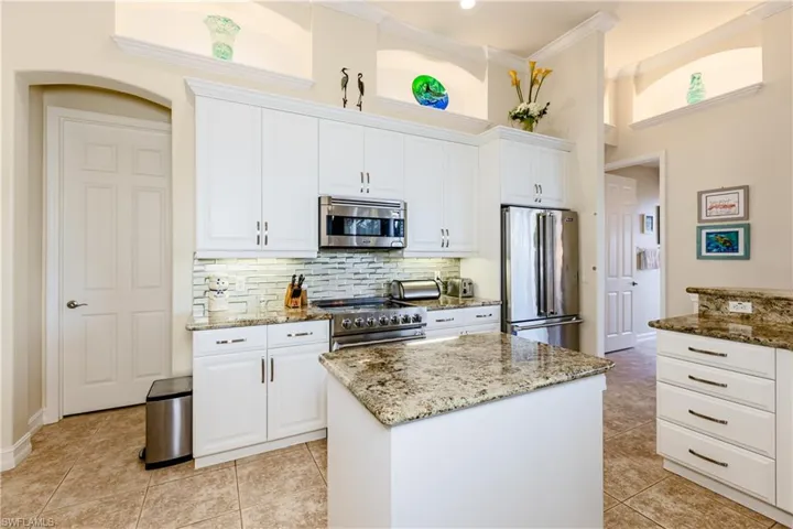 Kitchen featuring appliances with stainless steel finishes, white cabinets, and crown molding