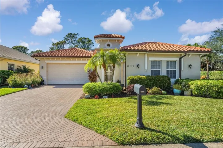 Mediterranean / spanish home featuring an attached garage, decorative driveway, stucco siding, a front yard, and a tiled roof