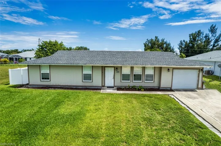 Ranch-style house with a garage, a front yard, and central AC