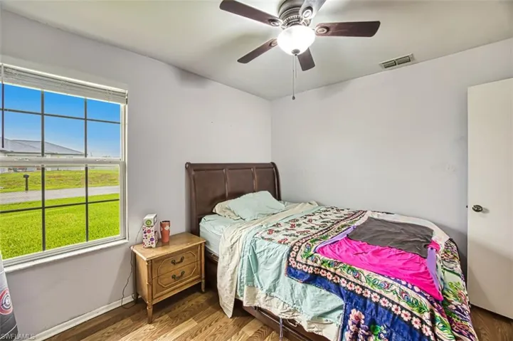 Bedroom with ceiling fan and wood-type flooring