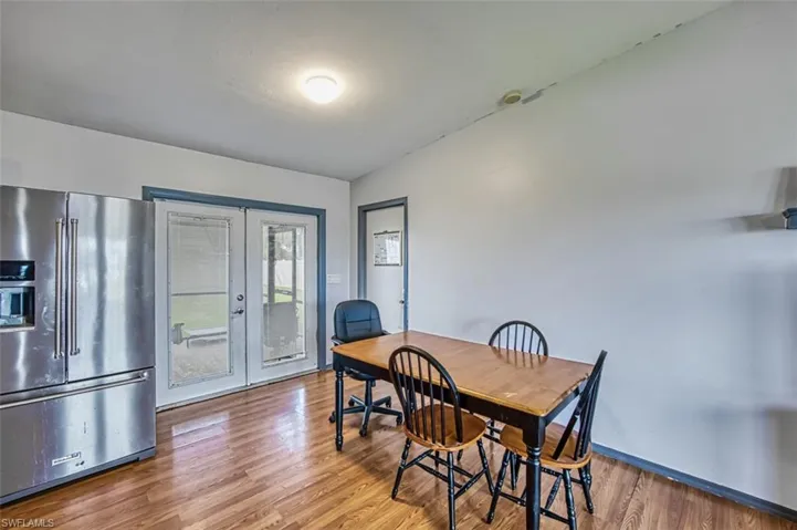 Dining space with hardwood / wood-style flooring, french doors, and lofted ceiling