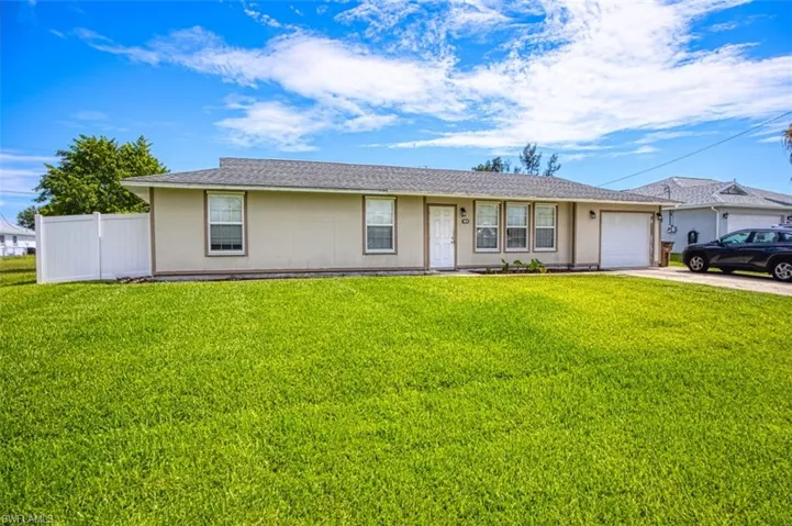 Ranch-style house featuring a garage and a front lawn
