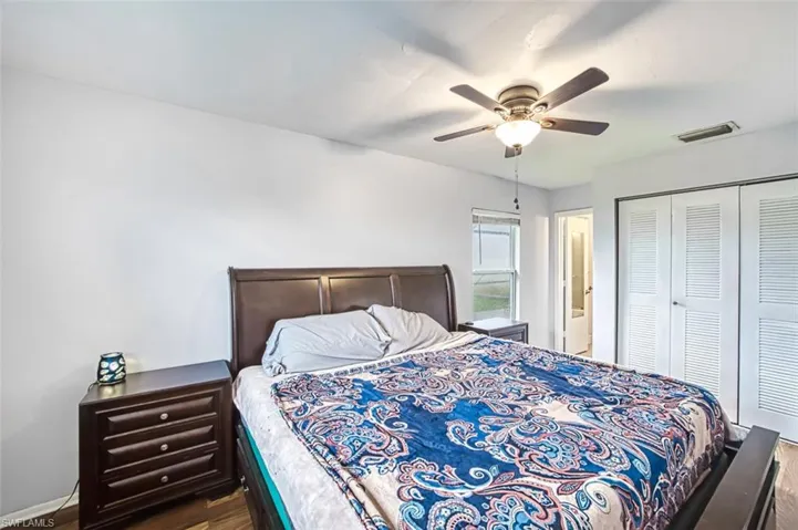 Bedroom with ceiling fan, a closet, and wood-type flooring