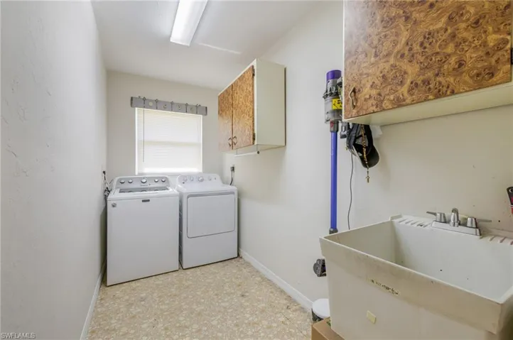 Laundry room featuring light flooring, washer and dryer, and cabinet space
