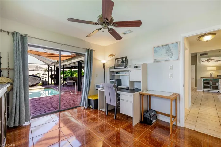 Tiled office space with ceiling fan and a sunroom