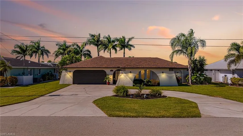 View of front of house featuring driveway, stucco siding, and an attached garage