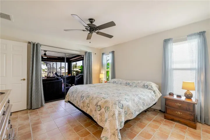 Bedroom with light tile patterned flooring and ceiling fan
